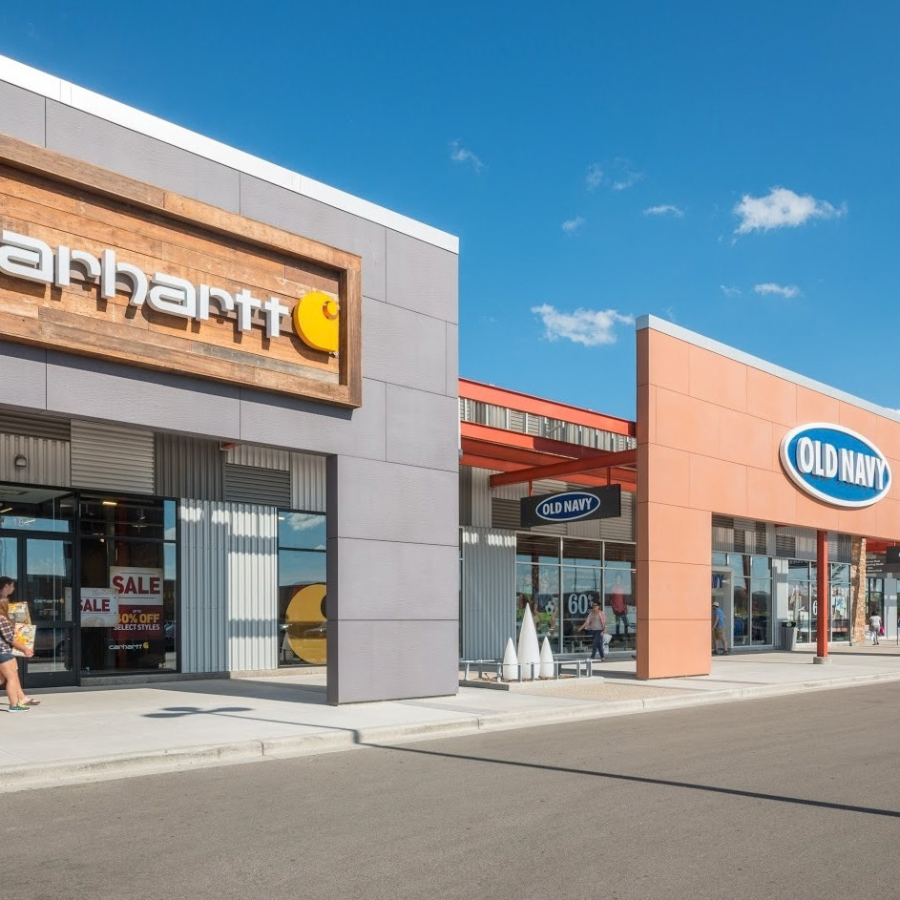 Carhartt and Old Navy stores in an outdoor shopping center under a blue sky.